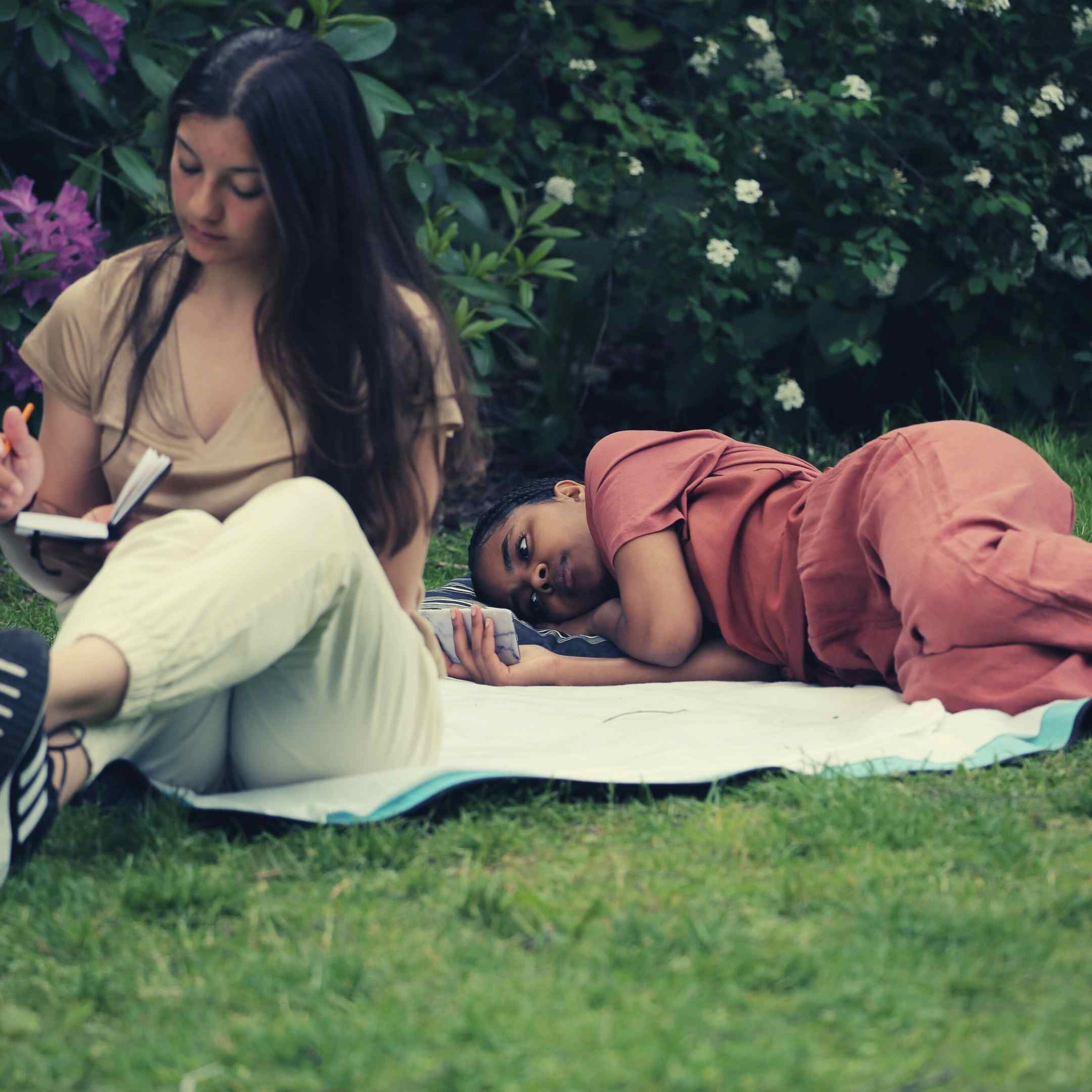 Två flickor som vilar på en filt